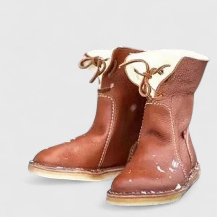 Woman wearing ankle boots with faux fur cuff and lace-up front, styled with jeans._4