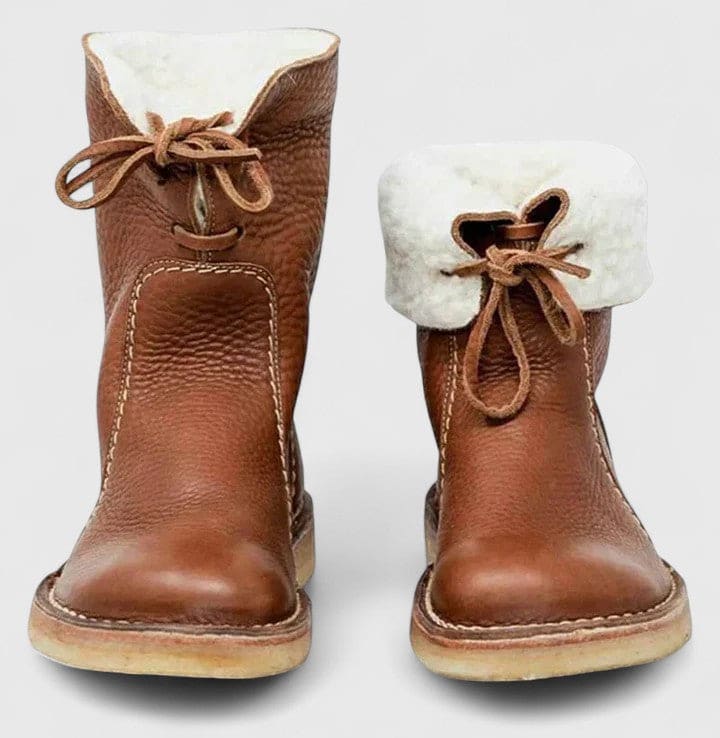 Woman wearing ankle boots with faux fur cuff and lace-up front, styled with jeans._7