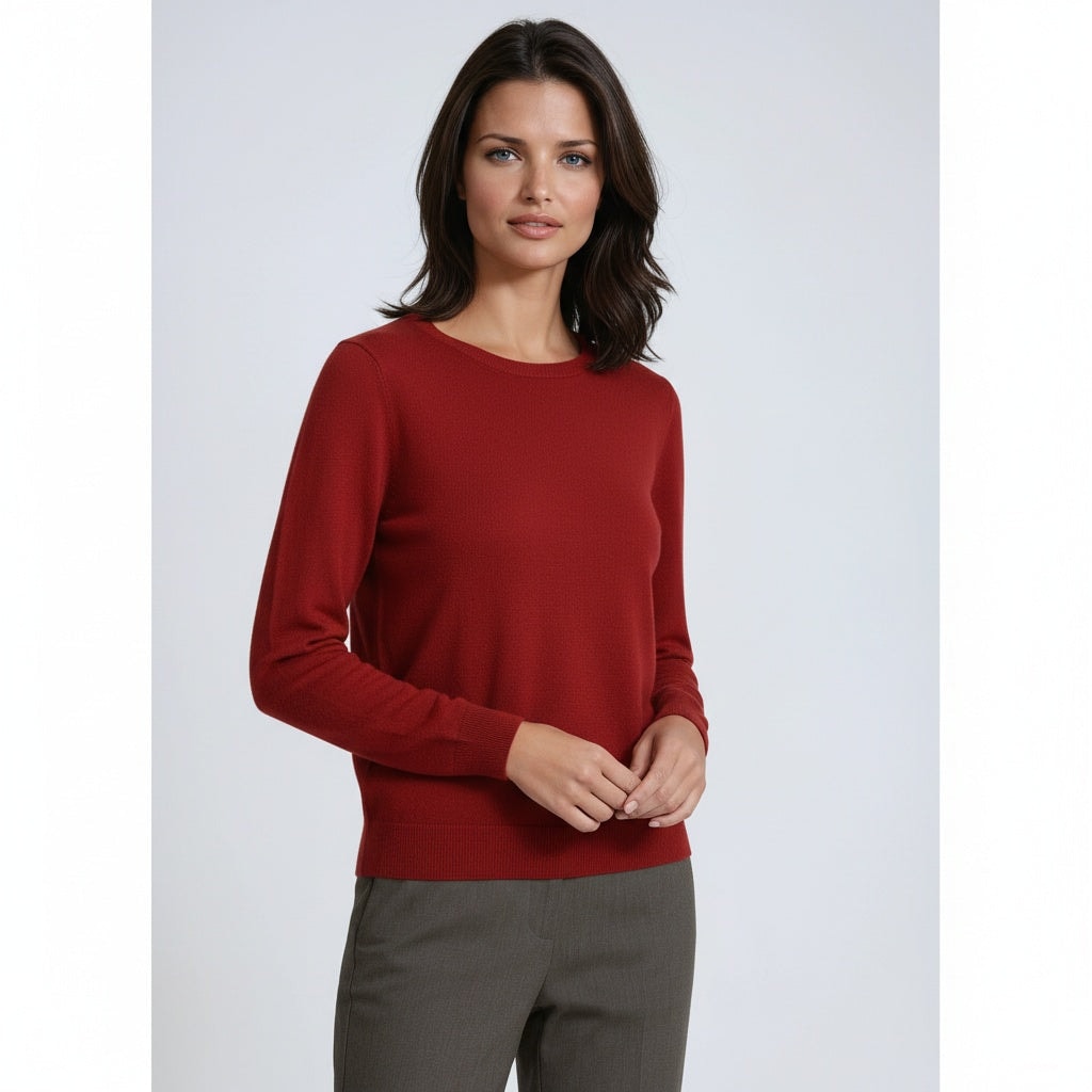 Front view of a red crew neck sweater with long sleeves and a simple fitted shape, paired with gray trousers.