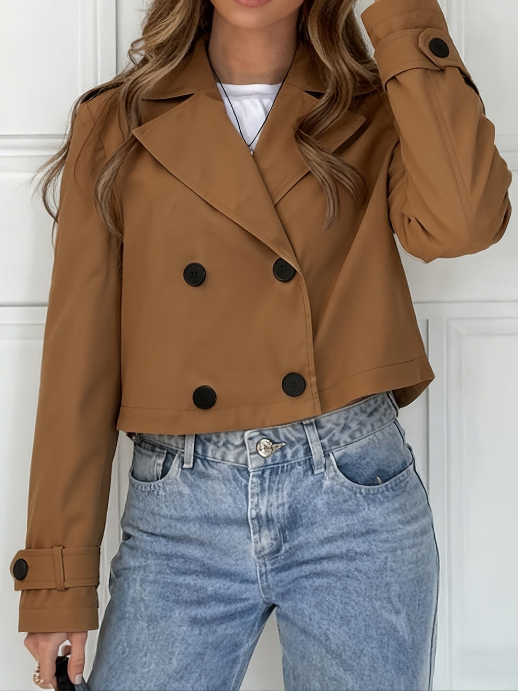 Woman wearing a cropped double breasted pea coat with notched lapel over a white top and light blue jeans._0