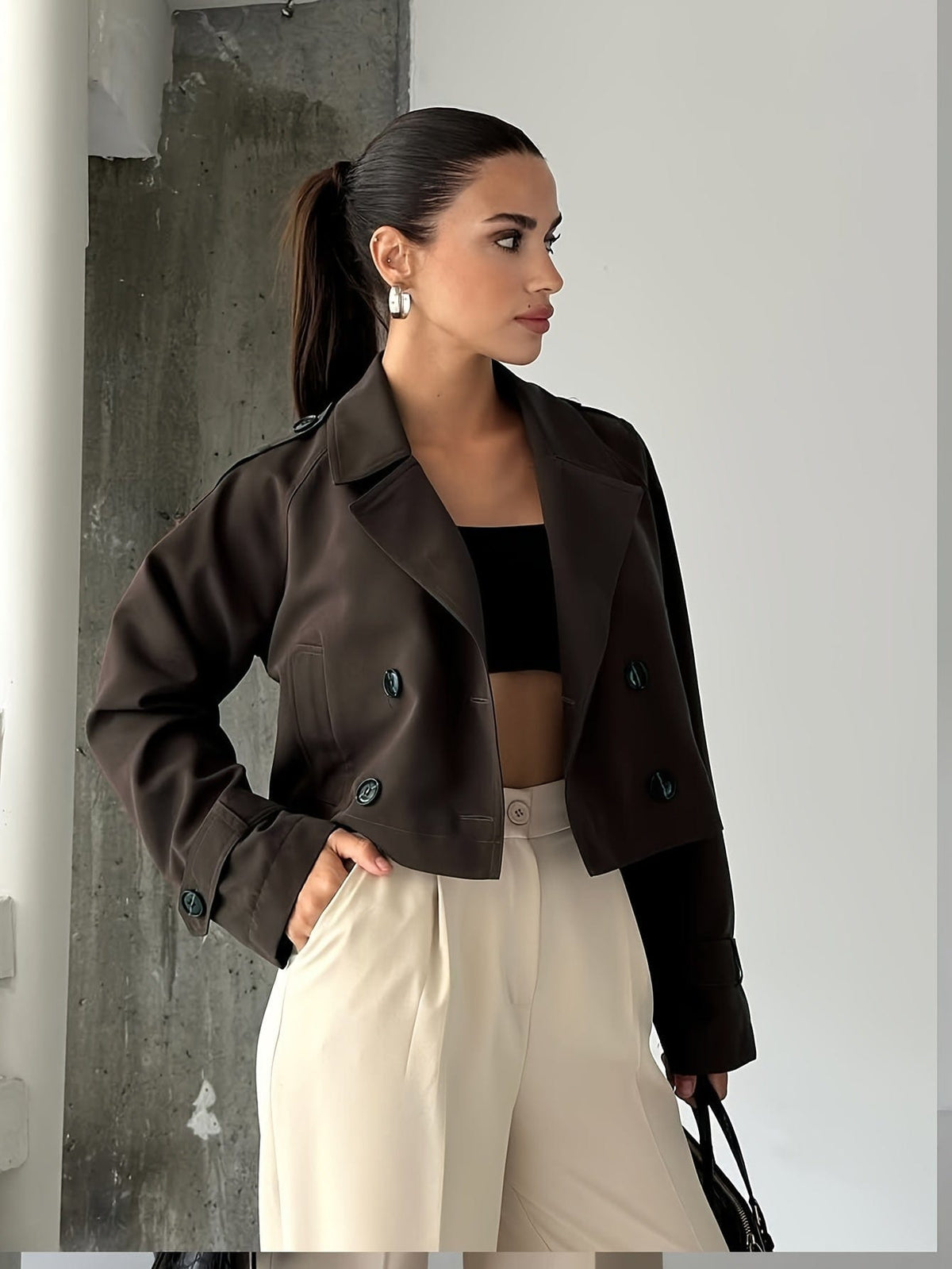 Woman wearing a cropped double breasted pea coat with notched lapel, long sleeves, and flap pockets, styled with high waisted trousers_0