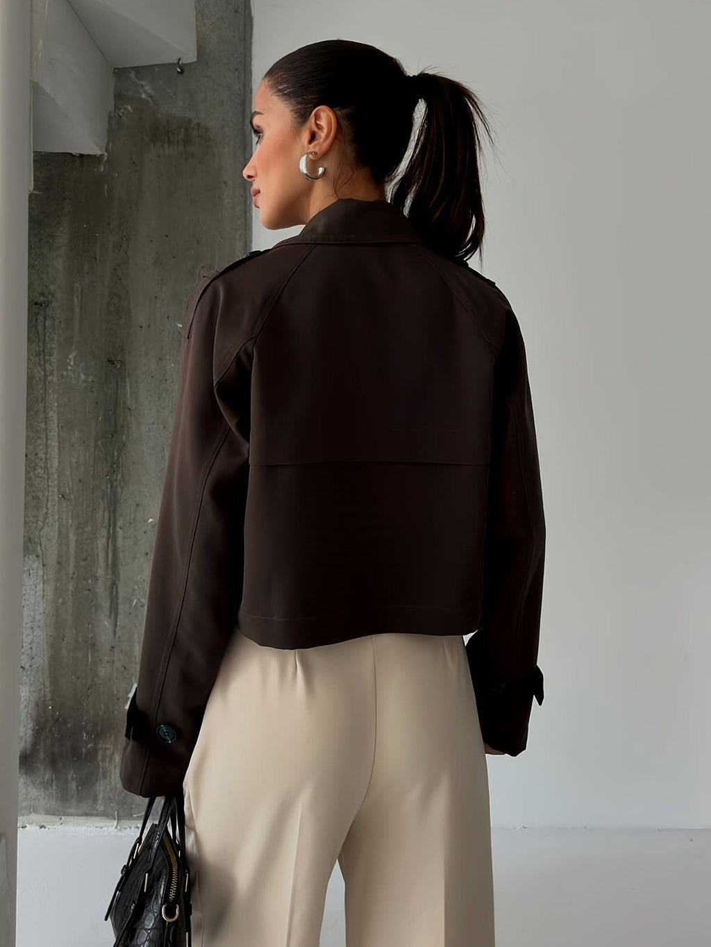 Woman wearing a cropped double breasted pea coat with notched lapel, long sleeves, and flap pockets, styled with high waisted trousers_4