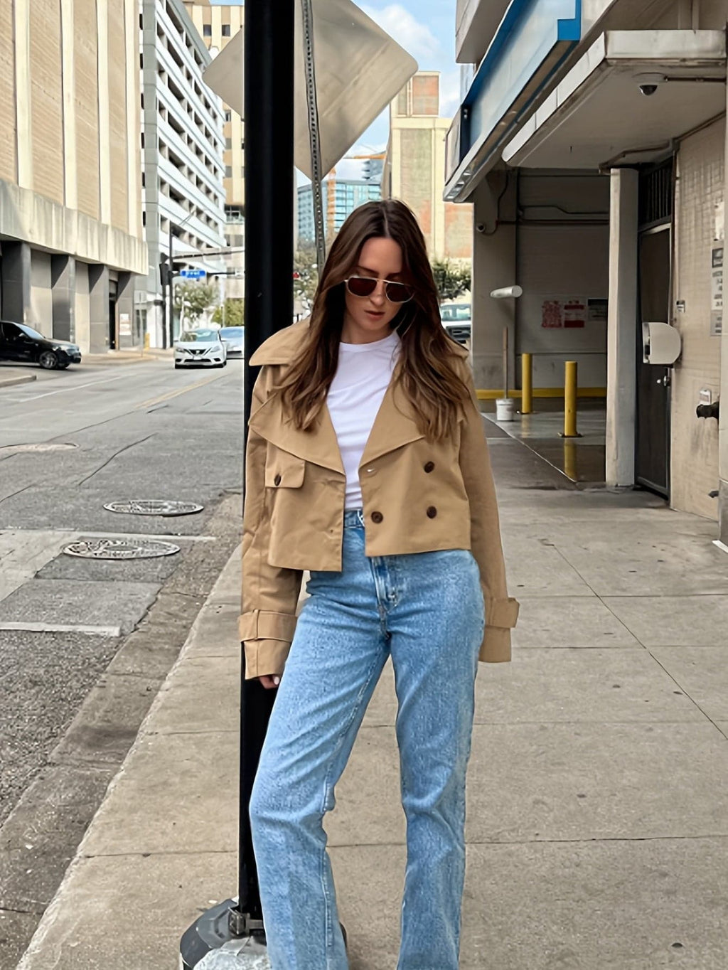 Woman wearing a cropped double breasted pea coat with notched lapel, long sleeves, and flap pockets, styled with high waisted trousers_5
