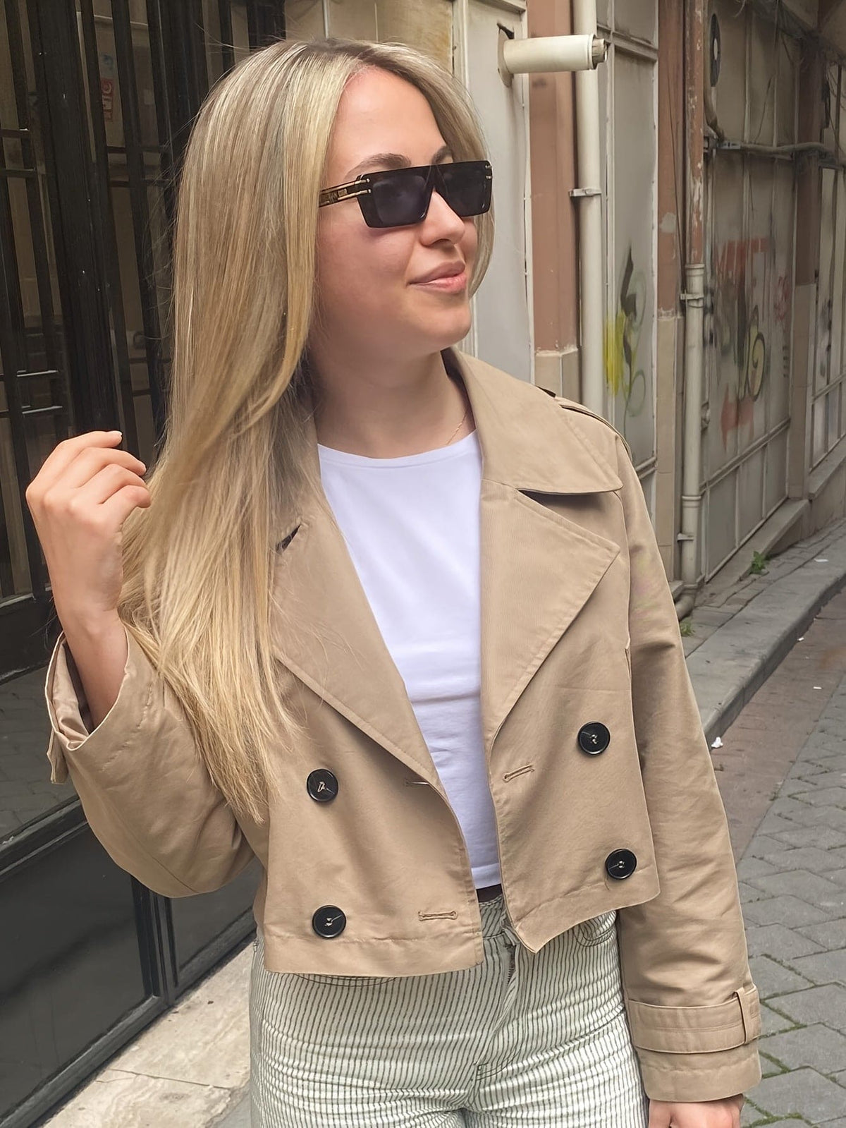 Woman wearing a cropped double breasted pea coat with notched lapel, long sleeves, and flap pockets, styled with high waisted trousers_9