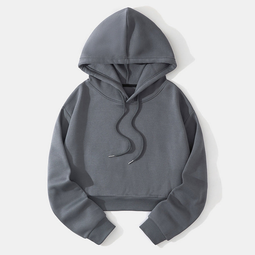 Charcoal gray cropped hoodie laid flat, highlighting the raised hood, long sleeves, ribbed waistband, and dark drawstrings.