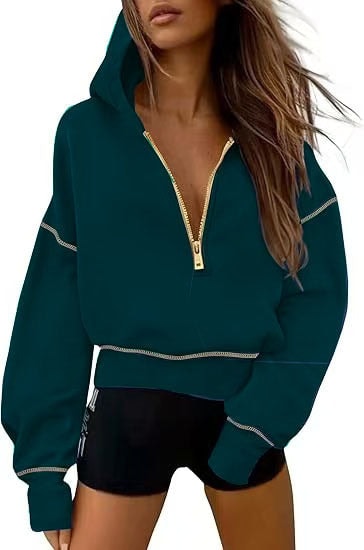 Deep teal cropped hooded hoodie featuring a gold half-zip and light contrast stitching on the sleeves and hem.