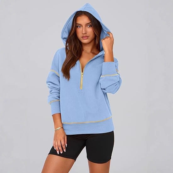 Blue cropped half-zip hoodie modeled with the hood up, black shorts, and yellow contrast stitching.