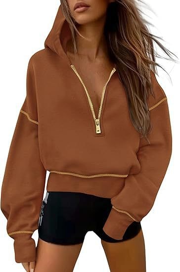 Brown cropped half-zip hoodie with a hood and gold contrast stitching along the shoulders, hem, and cuffs.