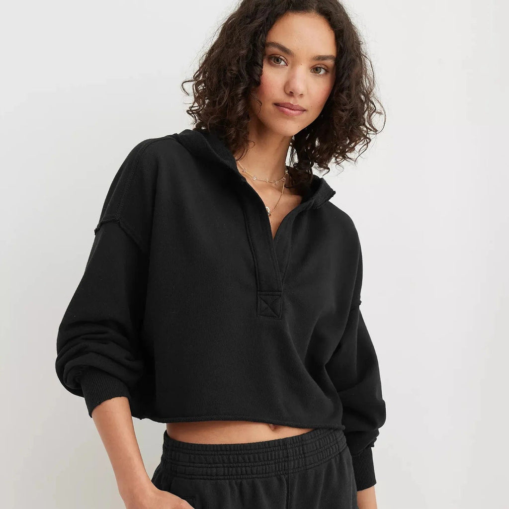 Woman wearing a relaxed cropped hoodie with collared neckline and long sleeves in a neutral indoor setting_10