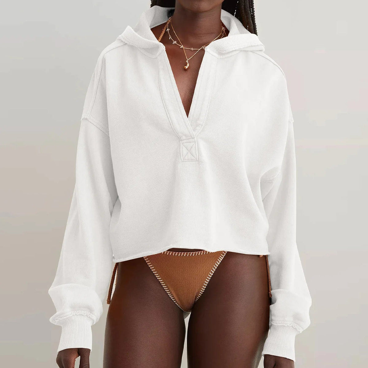 Woman wearing a relaxed cropped hoodie with collared neckline and long sleeves in a neutral indoor setting_11