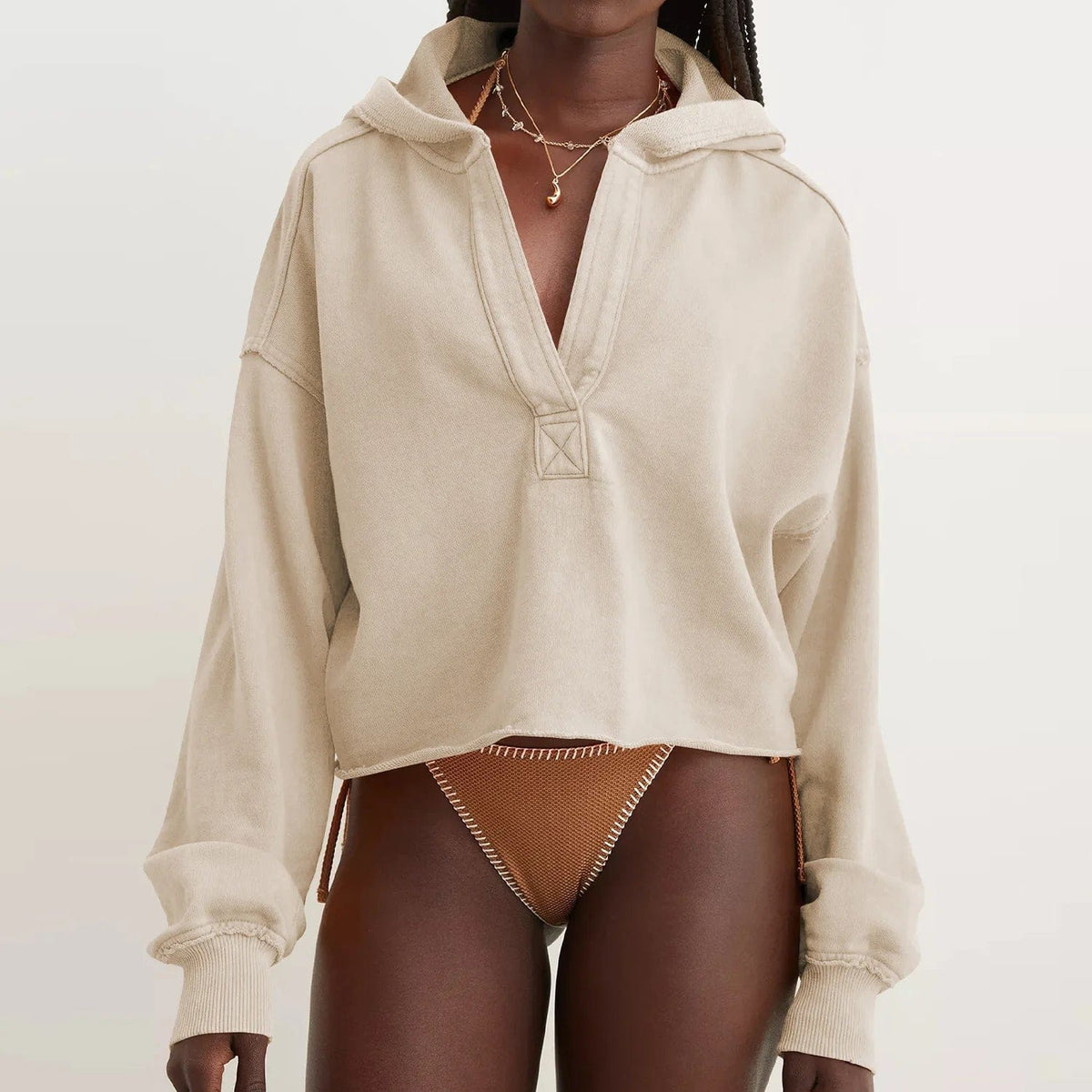 Woman wearing a relaxed cropped hoodie with collared neckline and long sleeves in a neutral indoor setting_12