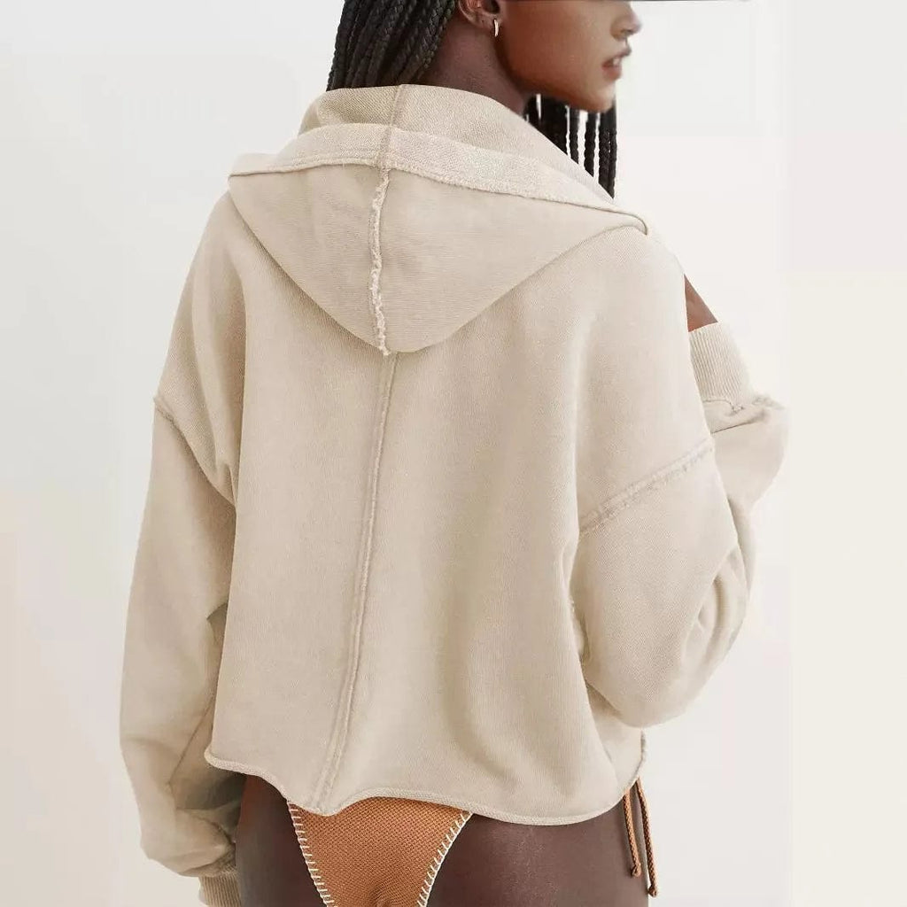 Woman wearing a relaxed cropped hoodie with collared neckline and long sleeves in a neutral indoor setting_16