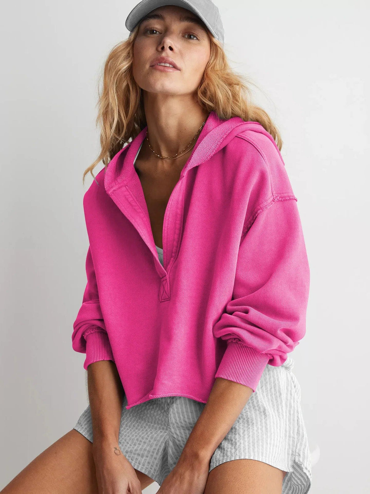 Woman wearing a relaxed cropped hoodie with collared neckline and long sleeves in a neutral indoor setting_17