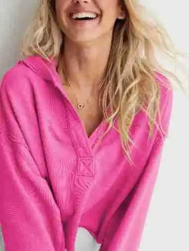 Woman wearing a relaxed cropped hoodie with collared neckline and long sleeves in a neutral indoor setting_18