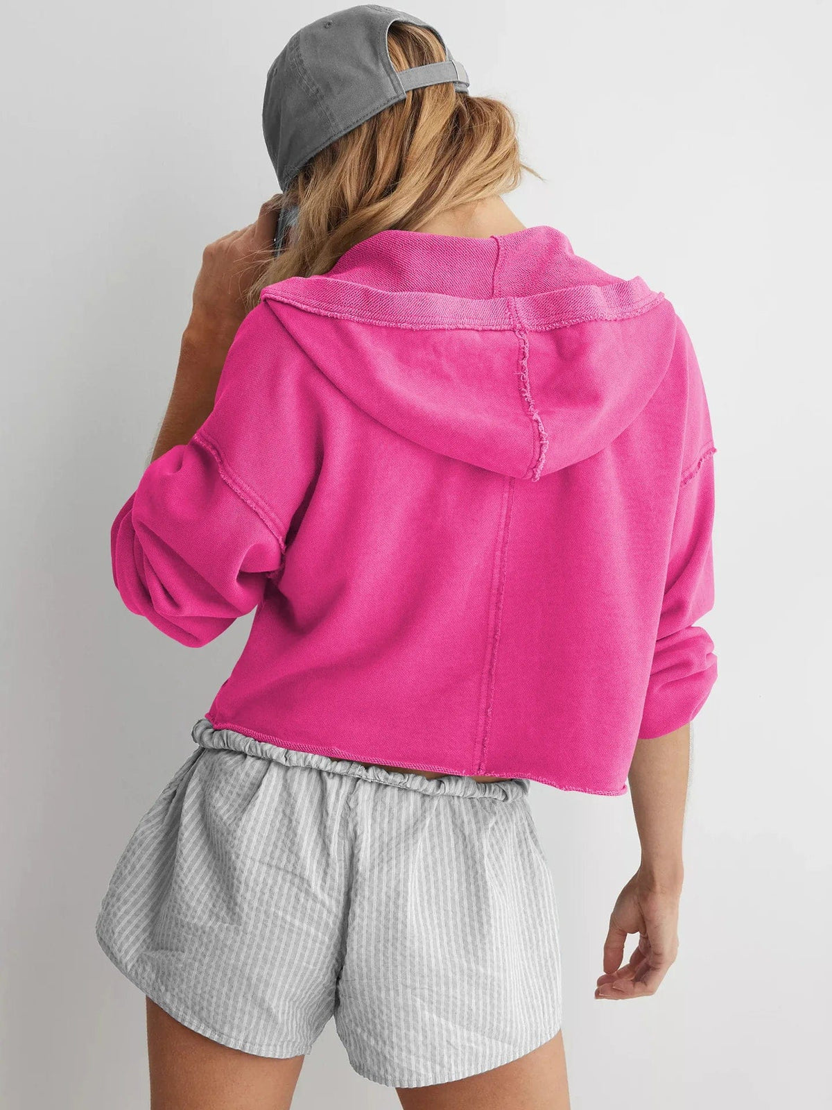 Woman wearing a relaxed cropped hoodie with collared neckline and long sleeves in a neutral indoor setting_19