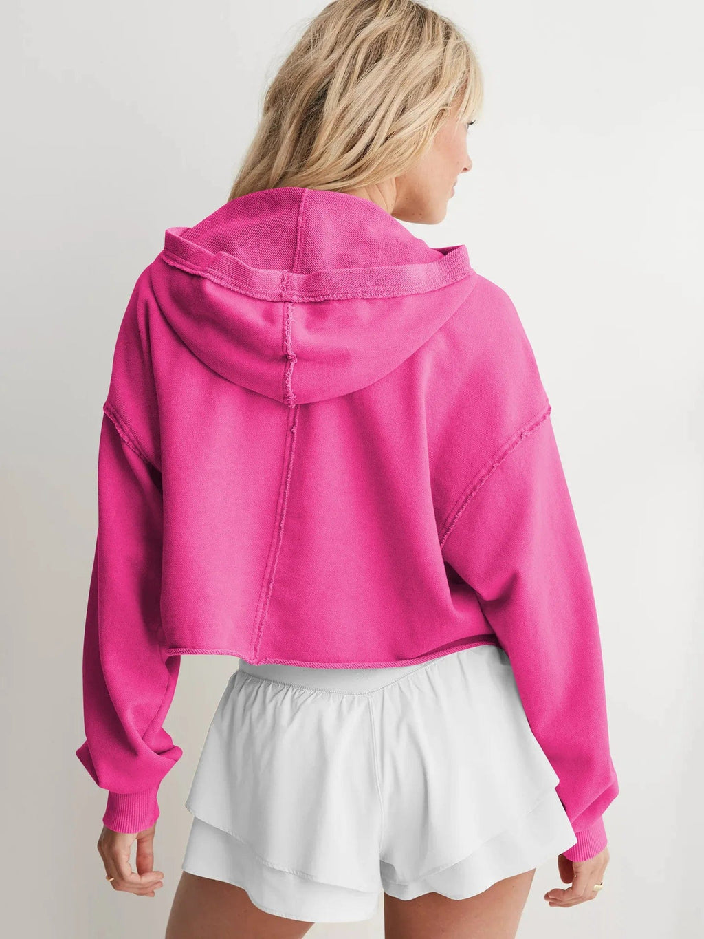 Woman wearing a relaxed cropped hoodie with collared neckline and long sleeves in a neutral indoor setting_21