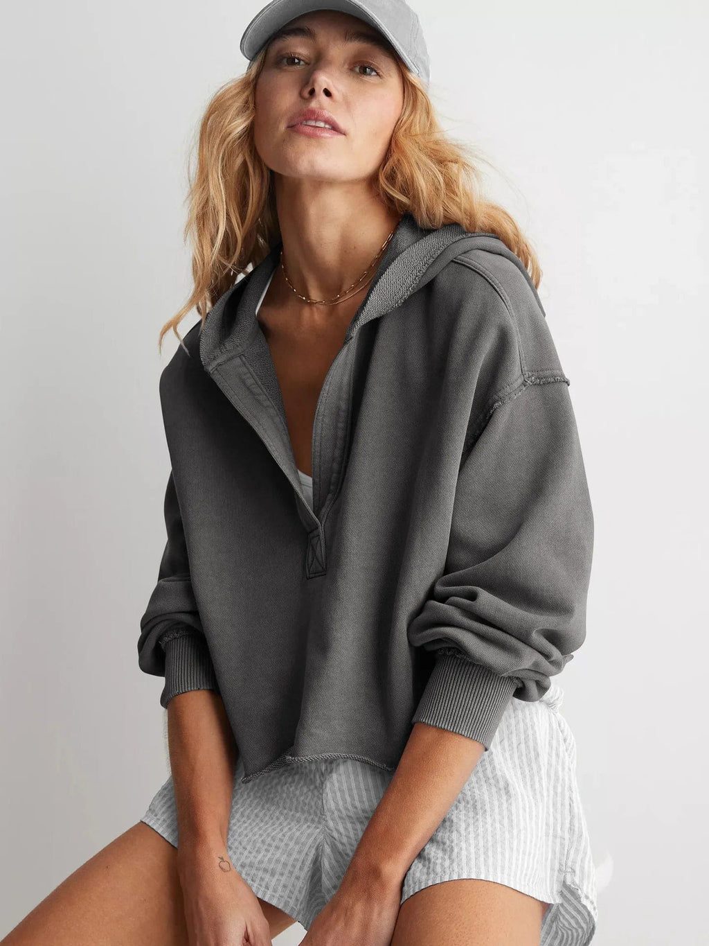 Woman wearing a relaxed cropped hoodie with collared neckline and long sleeves in a neutral indoor setting_27