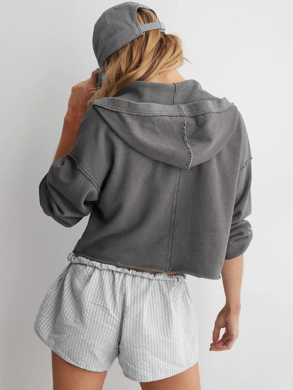 Woman wearing a relaxed cropped hoodie with collared neckline and long sleeves in a neutral indoor setting_28