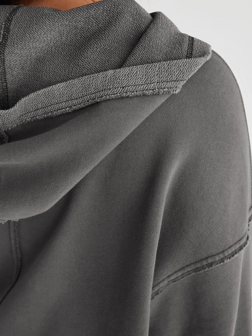 Woman wearing a relaxed cropped hoodie with collared neckline and long sleeves in a neutral indoor setting_31