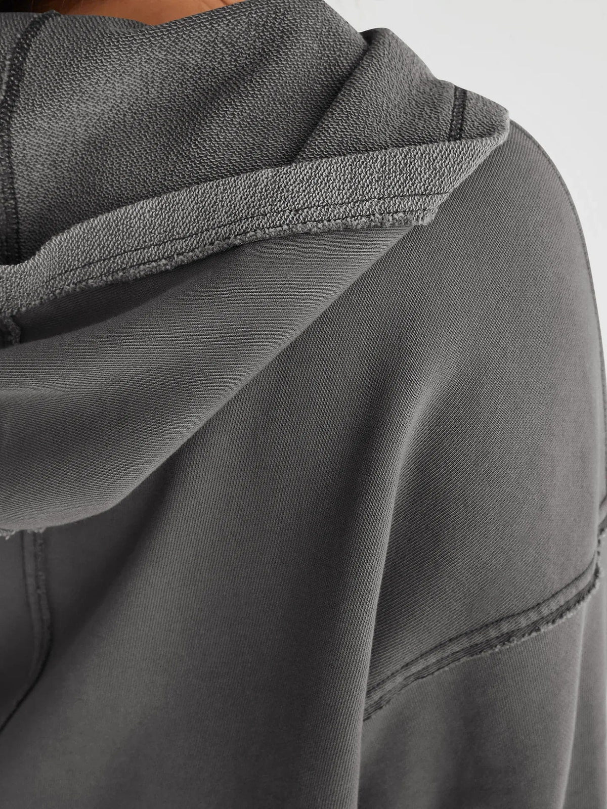 Woman wearing a relaxed cropped hoodie with collared neckline and long sleeves in a neutral indoor setting_31