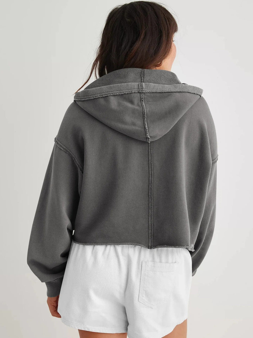 Woman wearing a relaxed cropped hoodie with collared neckline and long sleeves in a neutral indoor setting_33