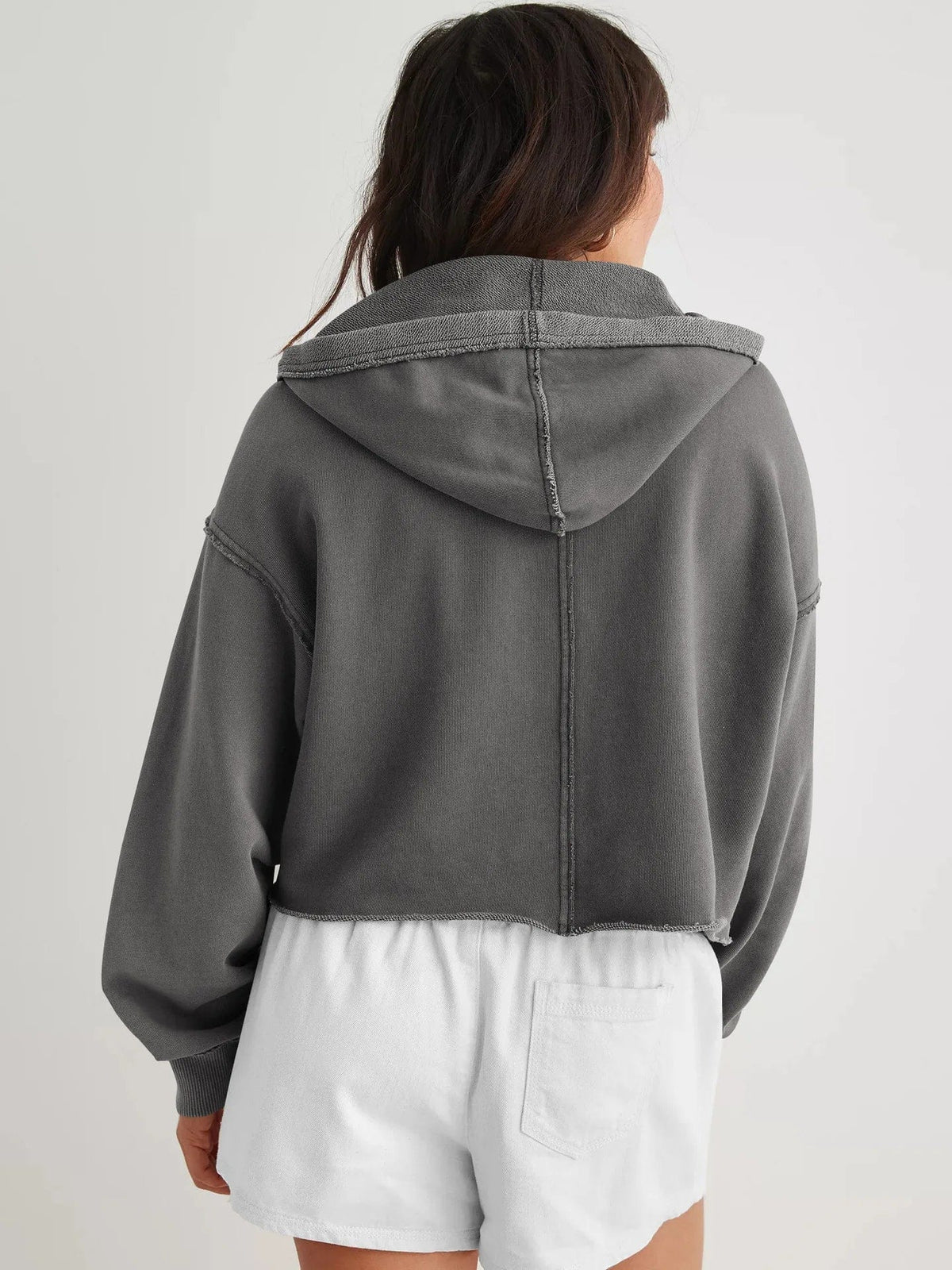 Woman wearing a relaxed cropped hoodie with collared neckline and long sleeves in a neutral indoor setting_33