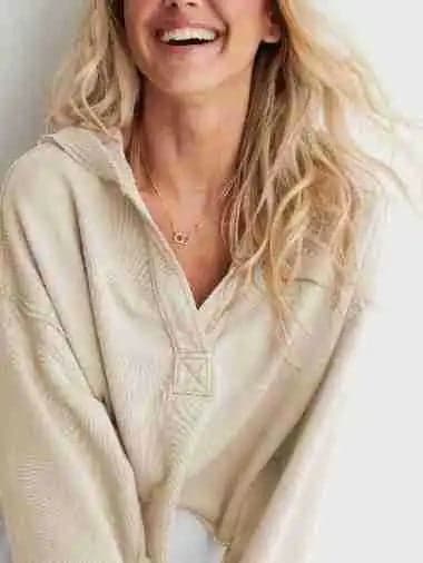 Woman wearing a relaxed cropped hoodie with collared neckline and long sleeves in a neutral indoor setting_35