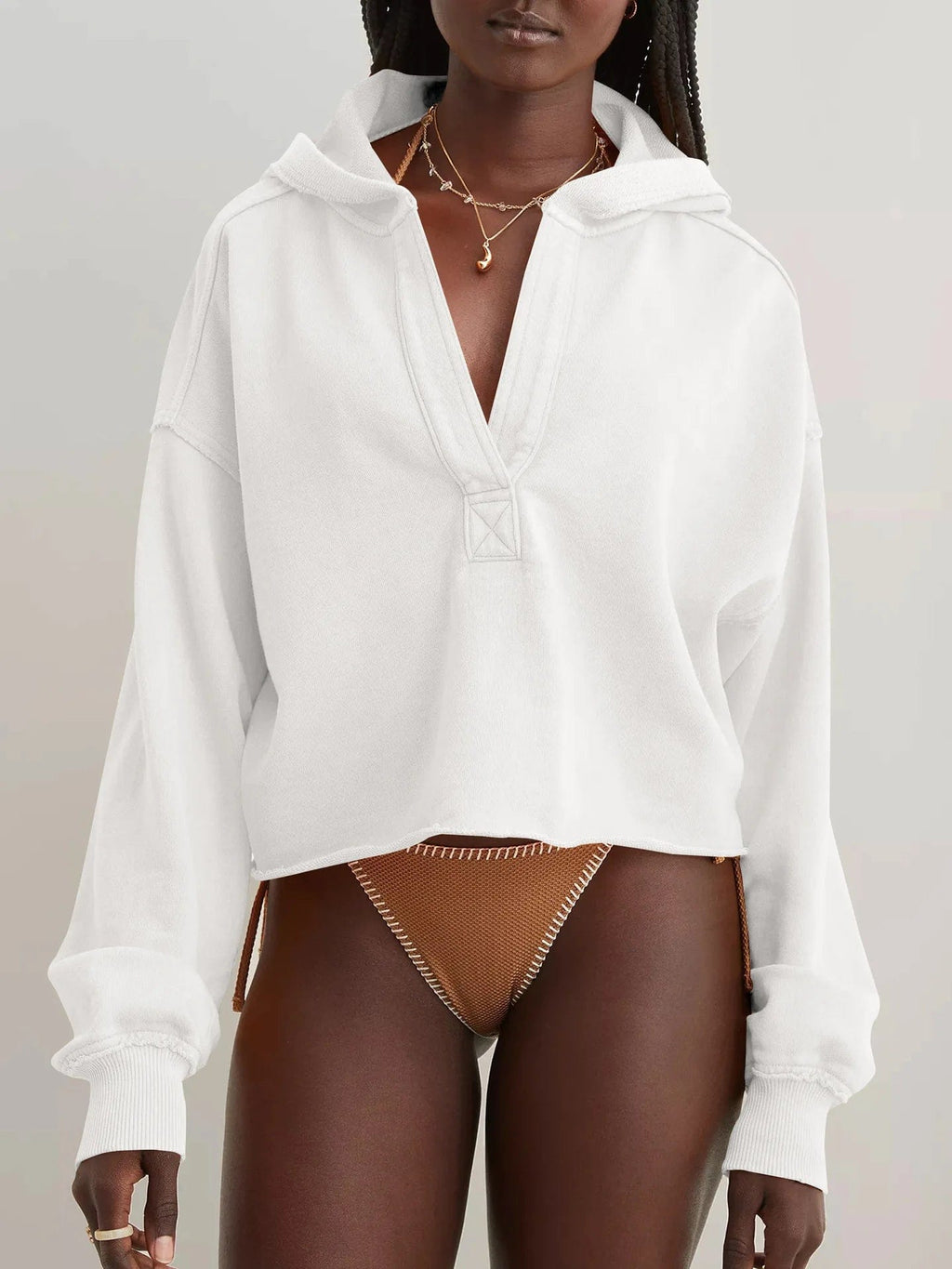 Woman wearing a relaxed cropped hoodie with collared neckline and long sleeves in a neutral indoor setting_43