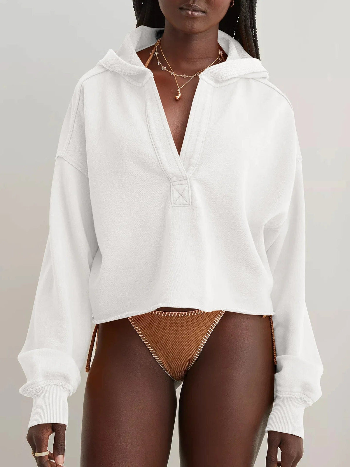 Woman wearing a relaxed cropped hoodie with collared neckline and long sleeves in a neutral indoor setting_43