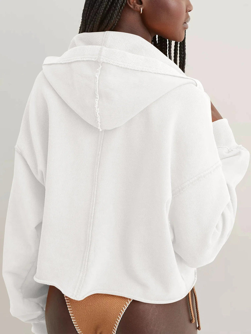 Woman wearing a relaxed cropped hoodie with collared neckline and long sleeves in a neutral indoor setting_46