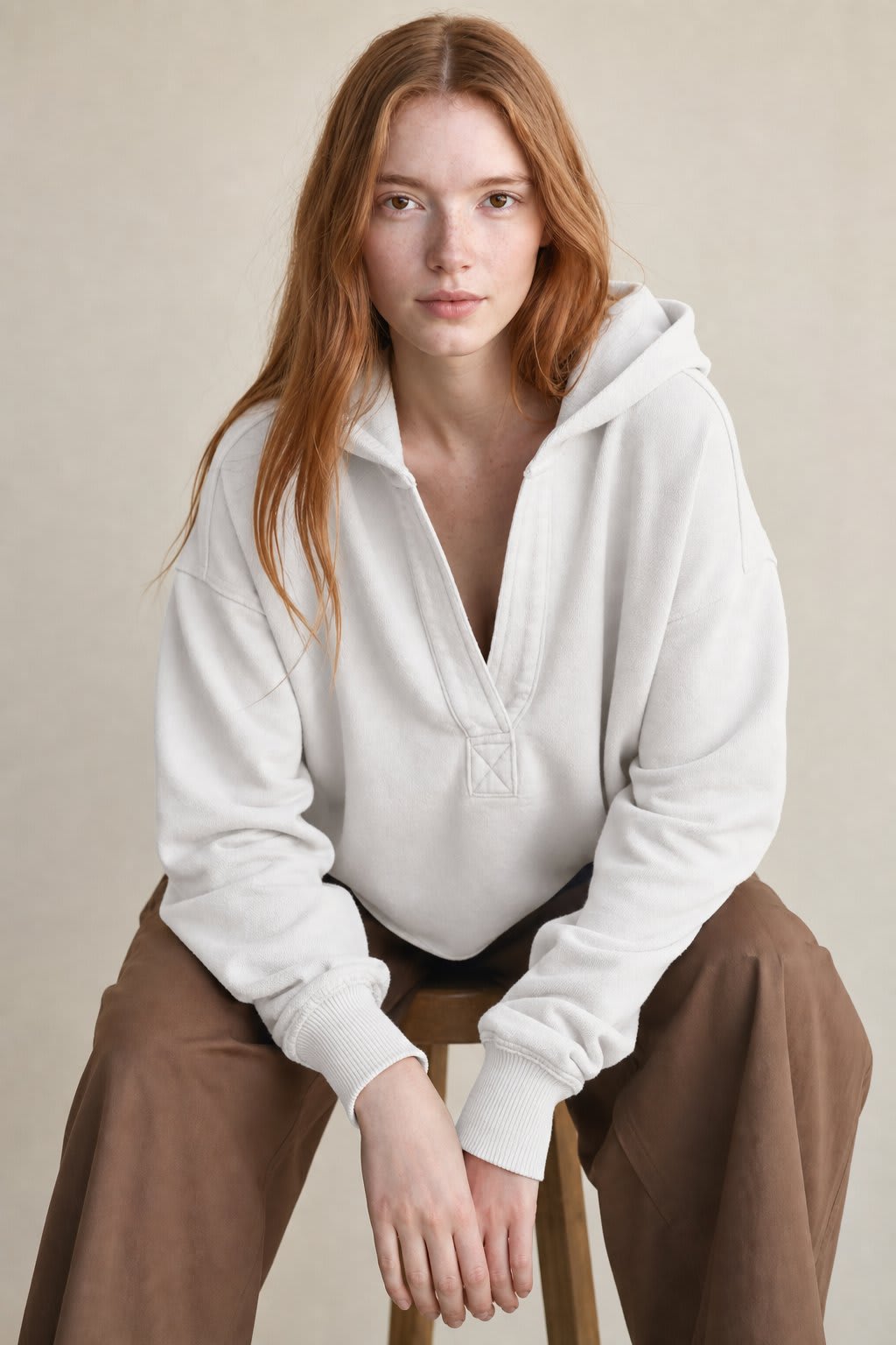 Woman wearing a relaxed cropped hoodie with collared neckline and long sleeves in a neutral indoor setting_5