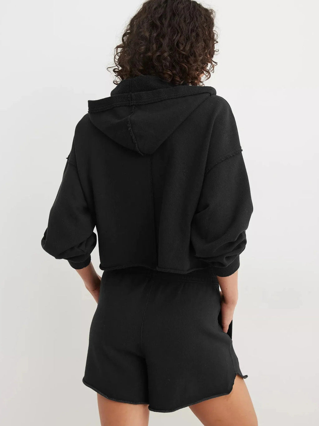Woman wearing a relaxed cropped hoodie with collared neckline and long sleeves in a neutral indoor setting_50
