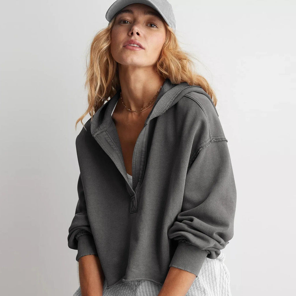 Woman wearing a relaxed cropped hoodie with collared neckline and long sleeves in a neutral indoor setting_9