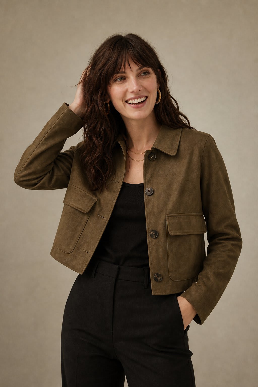 Woman wearing a cropped jacket with collared neckline, button front closure, and flap pockets over a black outfit._0
