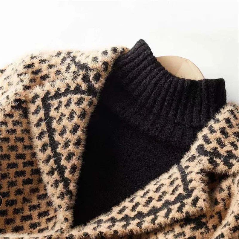Woman wearing a cropped houndstooth knit jacket with double-breasted buttons over a black turtleneck._11