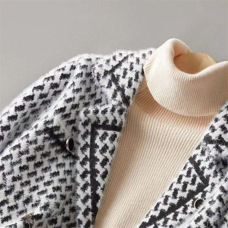 Woman wearing a cropped houndstooth knit jacket with double-breasted buttons over a black turtleneck._12
