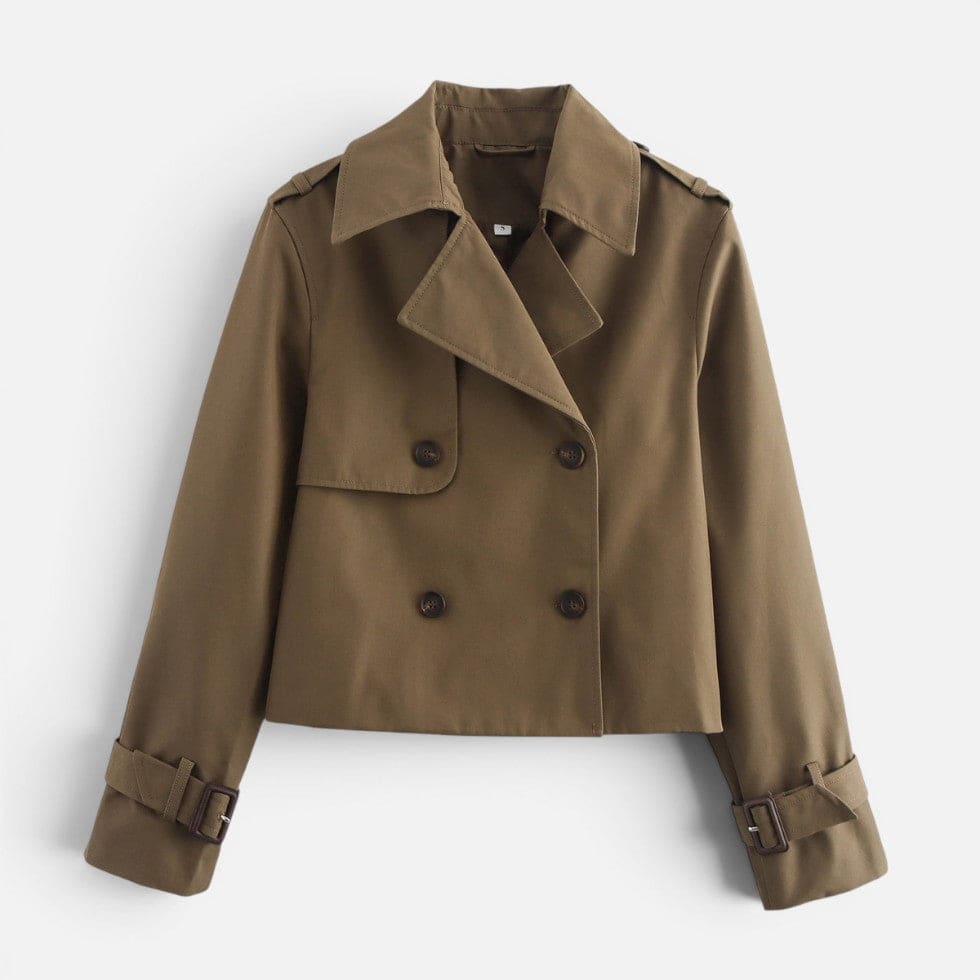 Cropped trench jacket in a neutral tone with double breasted button closure, notched lapel collar, shoulder epaulettes, and belted buckle cuffs displayed flat on a light background._0