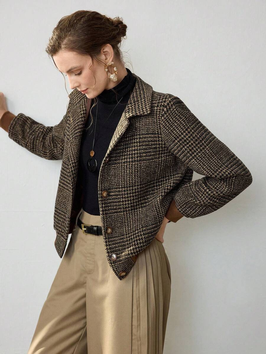 Woman wearing a cropped tweed blazer with houndstooth pattern over a black turtleneck and beige trousers._1