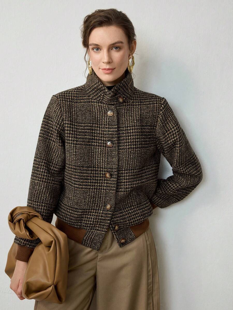 Woman wearing a cropped tweed blazer with houndstooth pattern over a black turtleneck and beige trousers._2