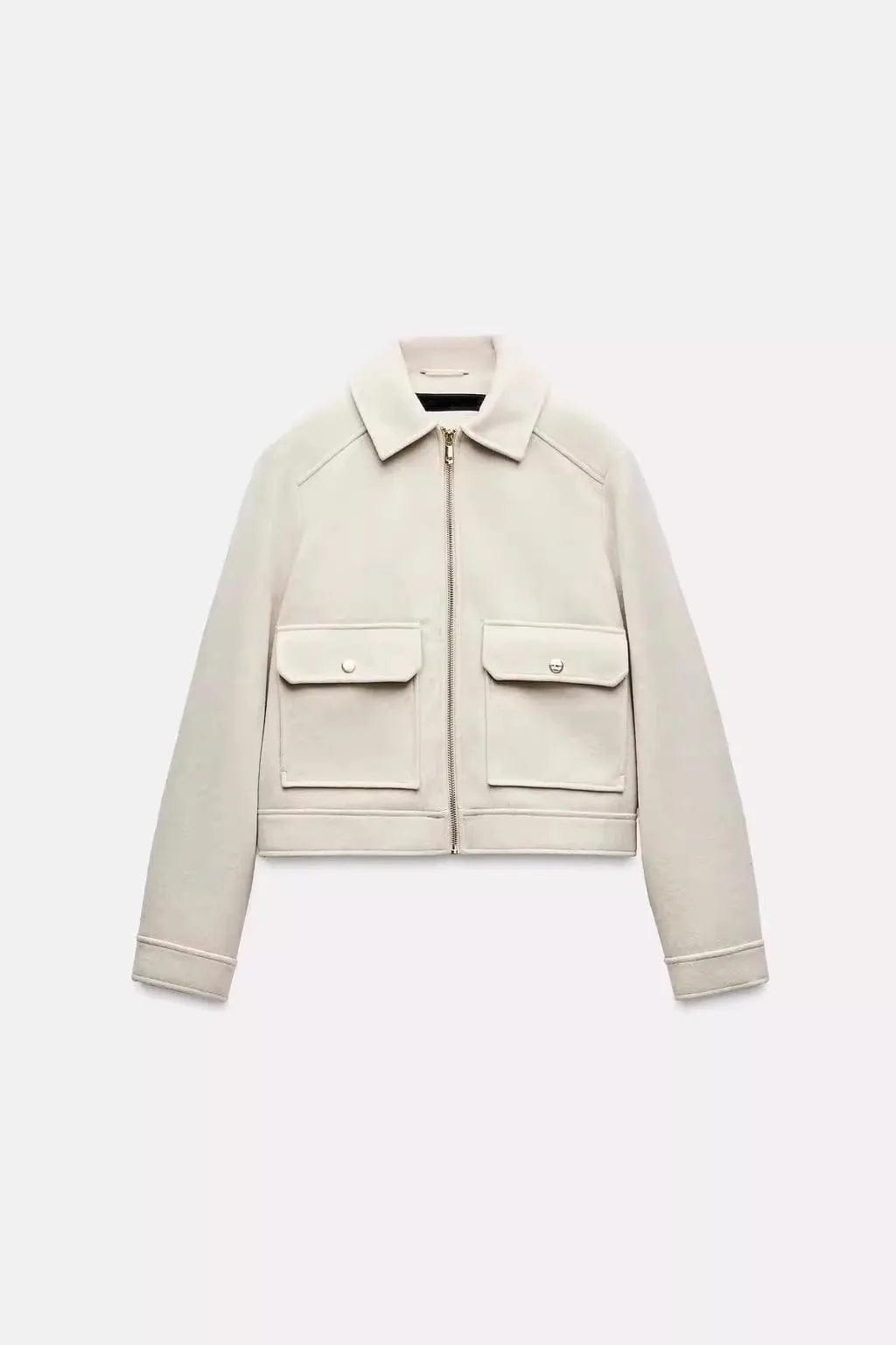 Woman wearing a cropped zip-front jacket with collar and chest pockets, styled over a light sweater and dark pants._11