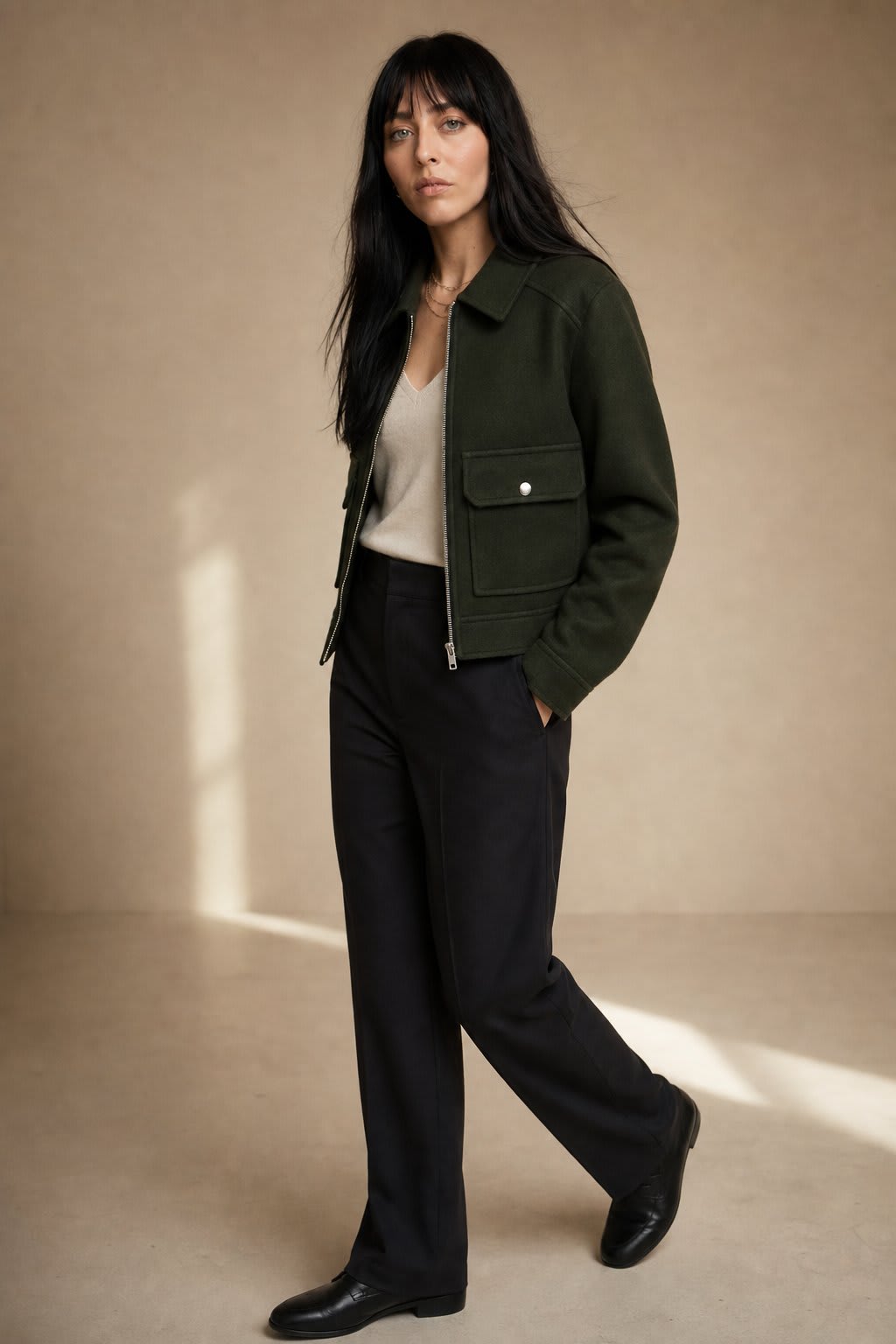 Woman wearing a cropped zip-front jacket with collar and chest pockets, styled over a light sweater and dark pants._4