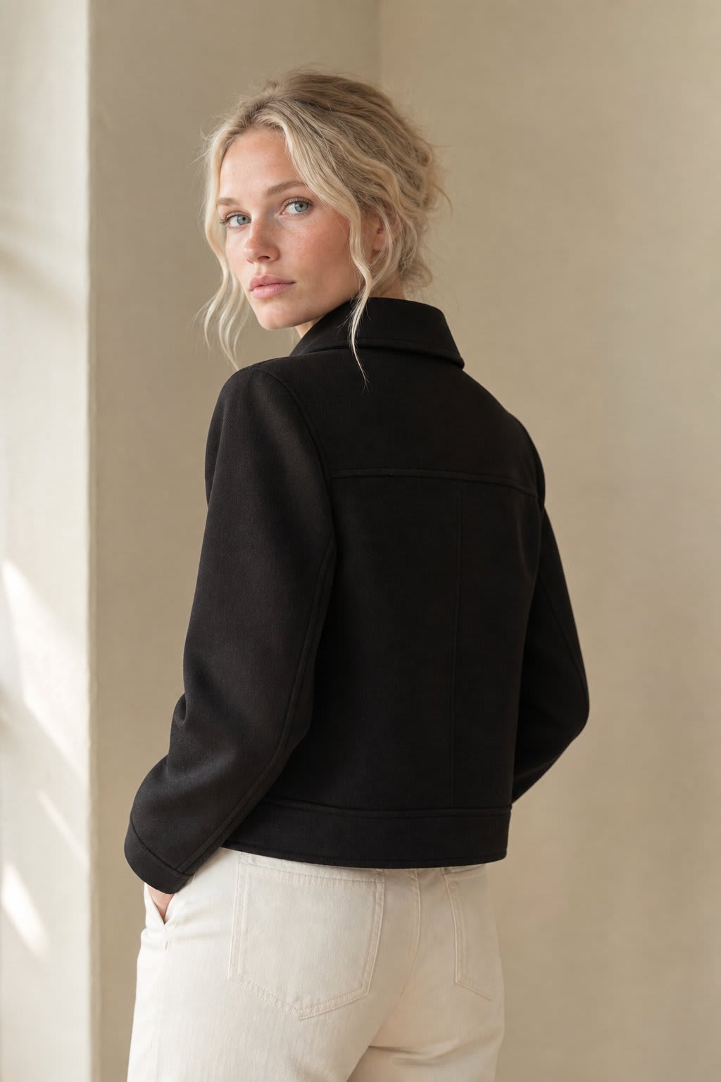 Woman wearing a cropped zip-front jacket with collar and chest pockets, styled over a light sweater and dark pants._6