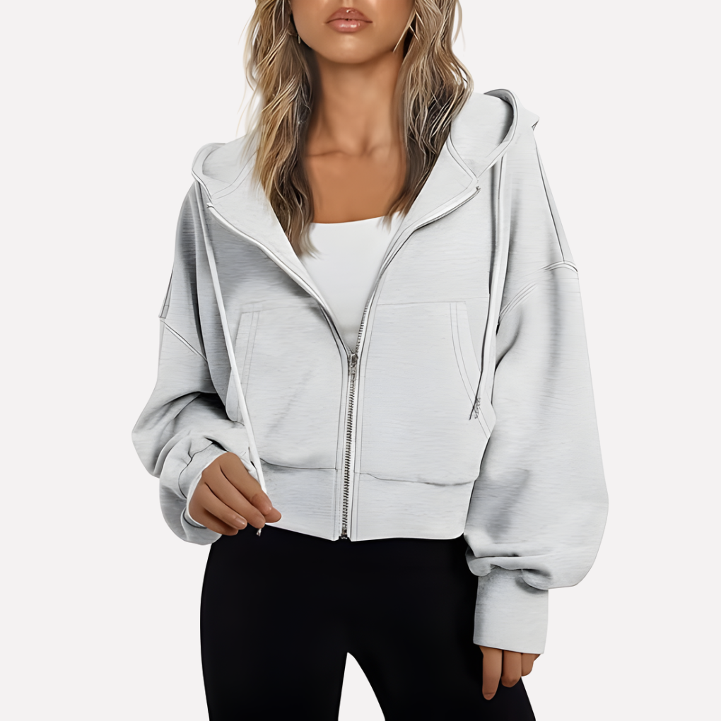 White cropped zip-up hoodie with a drawstring hood, roomy sleeves, front pockets, and ribbed cuffs and hem.