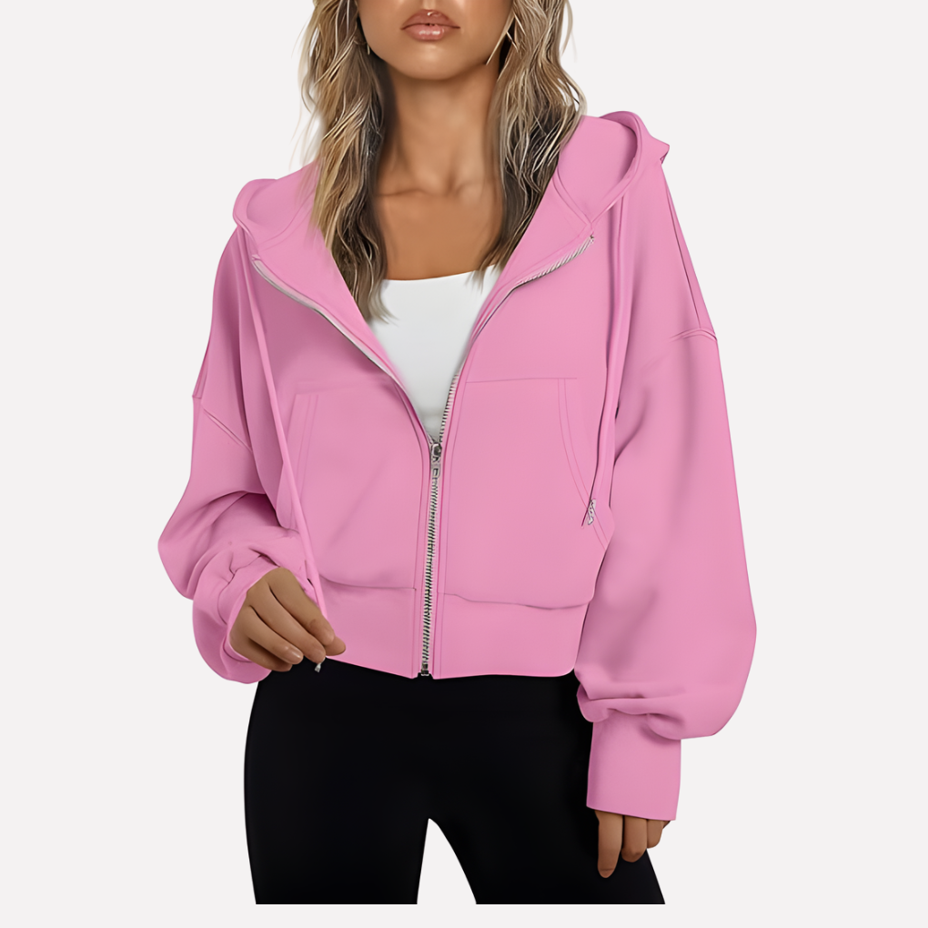 Bright pink cropped hoodie with a zip front, drawstring hood, roomy sleeves, front pockets, and ribbed trim.