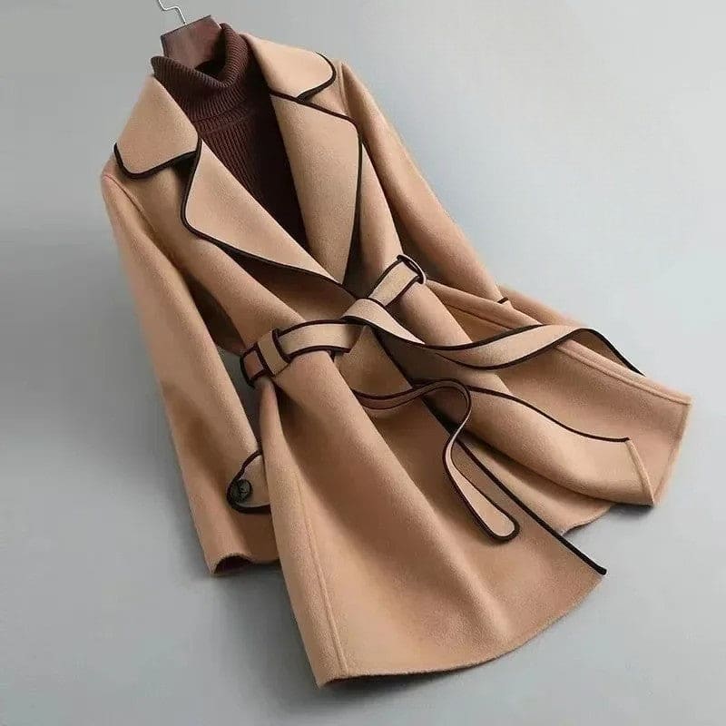 A wrap coat with contrast trim, a belted waist, and buttoned cuffs displayed against a light background._0