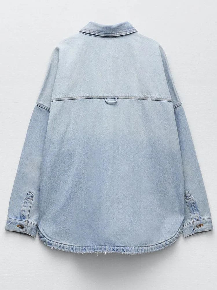 Woman wearing an oversized denim shirt jacket with button front, styled with matching jeans and neutral background._10