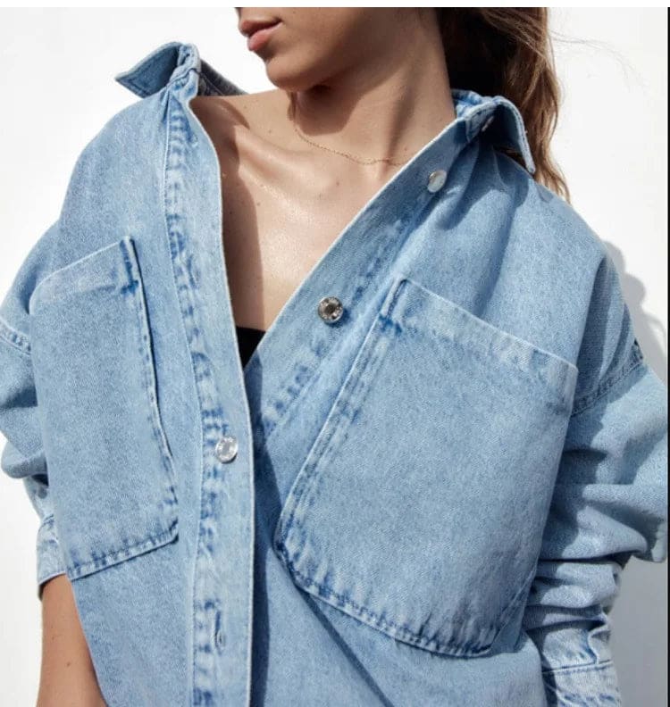 Woman wearing an oversized denim shirt jacket with button front, styled with matching jeans and neutral background._15