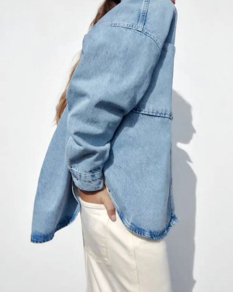 Woman wearing an oversized denim shirt jacket with button front, styled with matching jeans and neutral background._16
