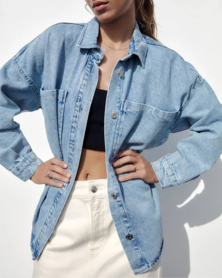 Woman wearing an oversized denim shirt jacket with button front, styled with matching jeans and neutral background._5