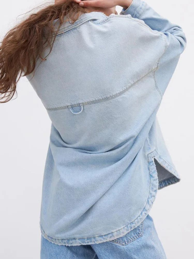 Woman wearing an oversized denim shirt jacket with button front, styled with matching jeans and neutral background._8